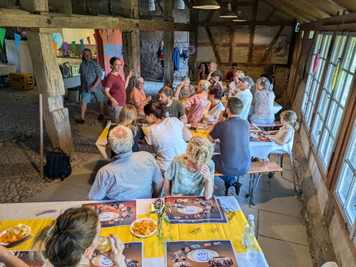 Mitglieder sitzen drinnen an den Tischen, während Annina zur Gruppe redet.